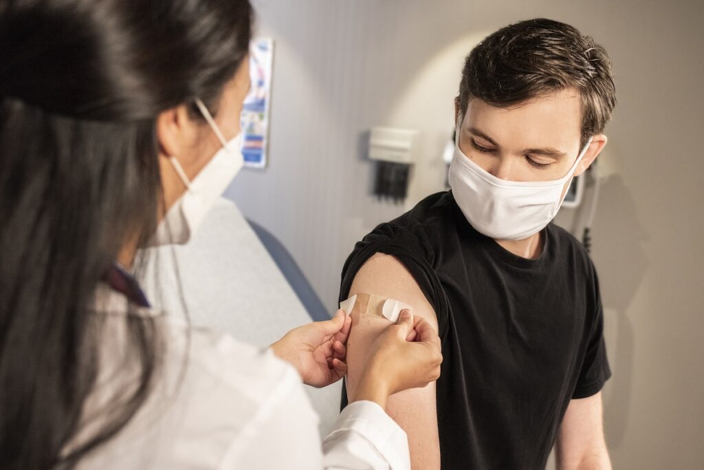 man receives COVID-19 vaccine from the CDC