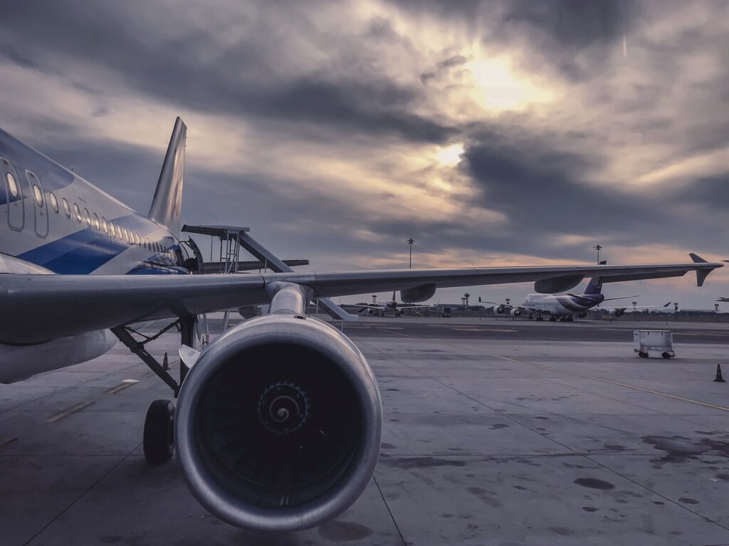 image of an airline engine and wing at sunset