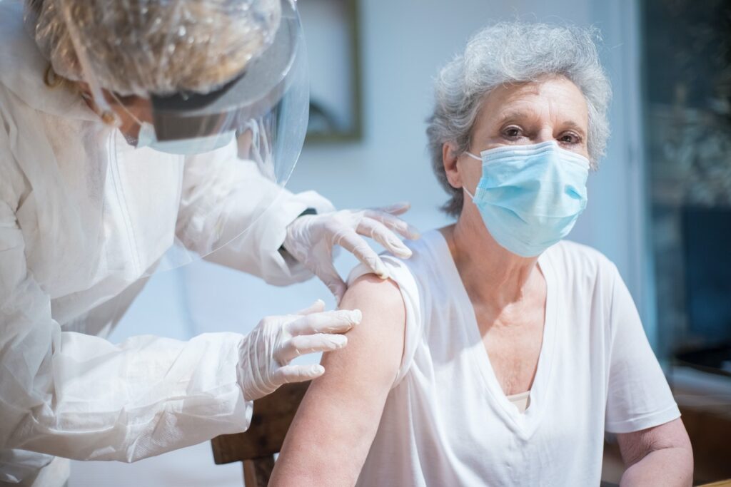 image of an older woman receiving a vaccine